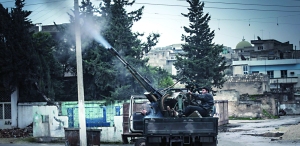 A Free Syrian Army fighter fires an anti-aircraft artillery weapon during an air strike in Binsh near Idlib